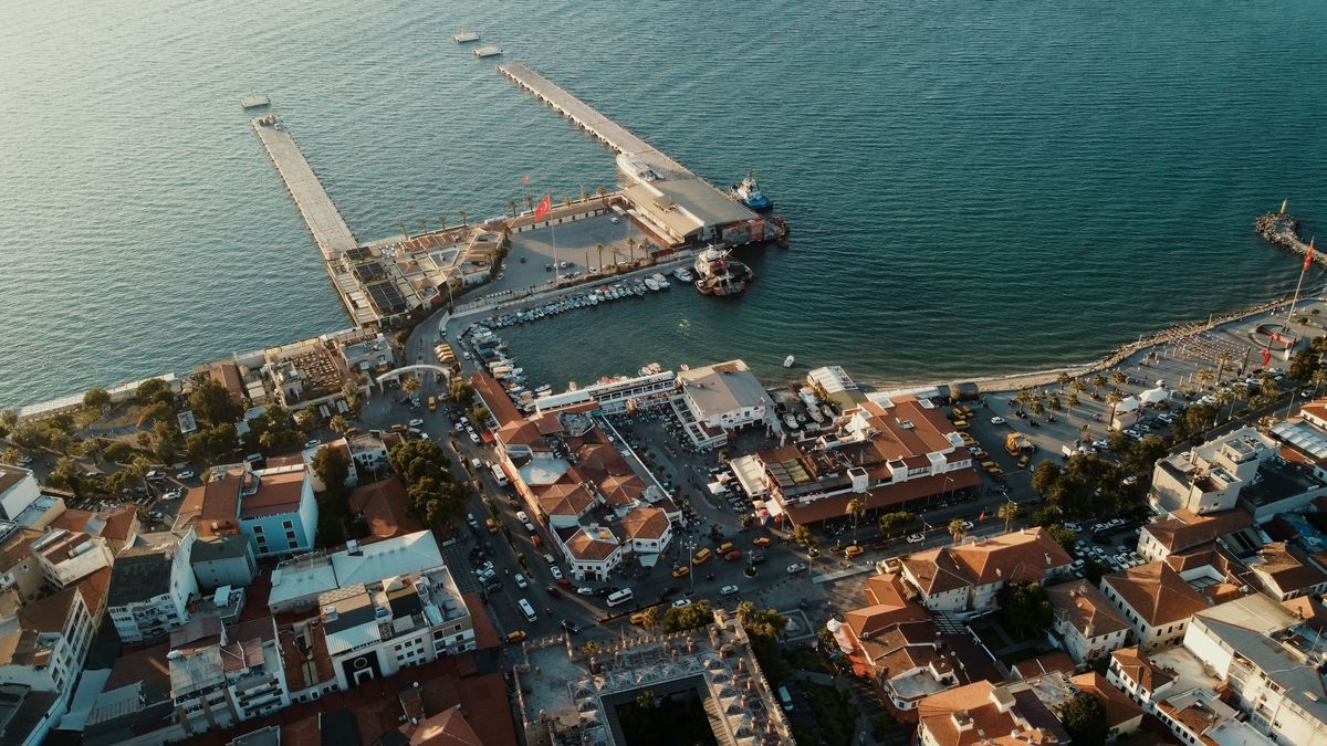 Aerial view of Kuşadası harbor, its cruise piers and the red-roofed old town at golden hour